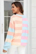Back view of a woman wearing a pastel striped color-block knit sweater