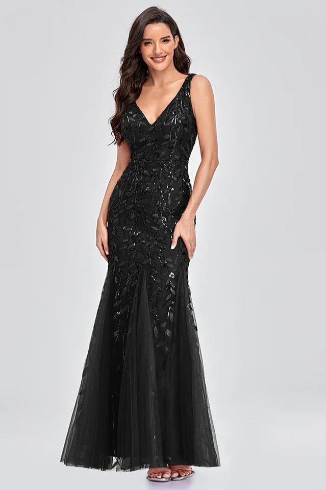 Woman wearing a floor-length black sequined mermaid gown with a V-neckline and sleeveless design.