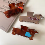 Collection of dachshund hair claw clips with different scarf designs on a table
