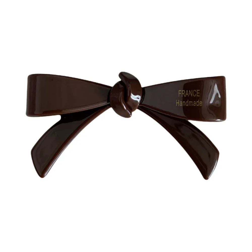 A single dark brown resin bow-shaped hair clip with the text "FRANCE Handmade" embossed on one side. Main image