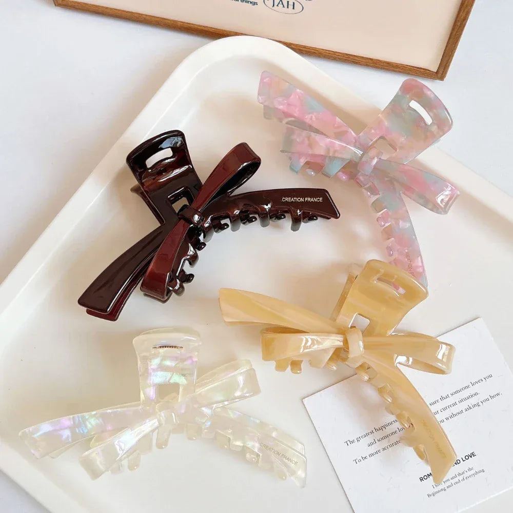 Collection of marbled bow claw hair clips arranged on a tray