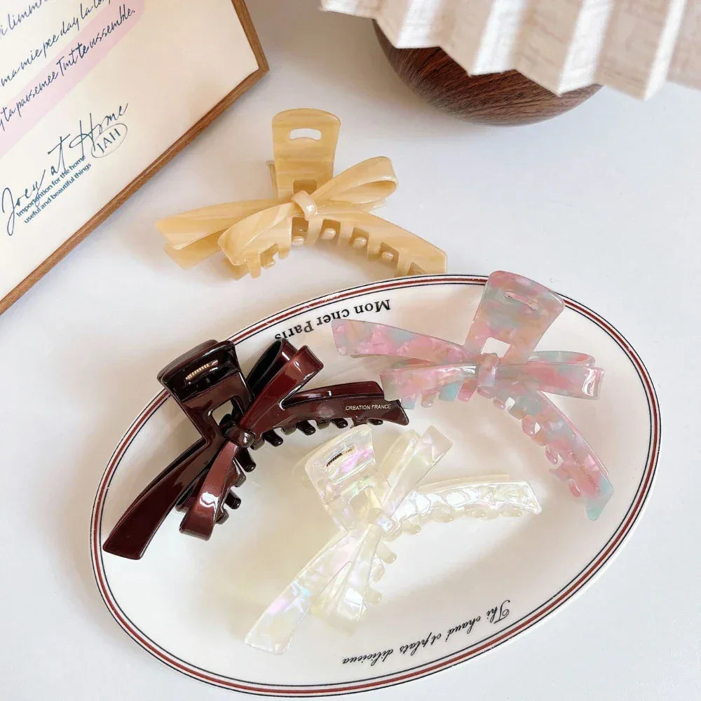 Marbled bow claw hair clips displayed on a plate