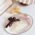 Marbled bow claw hair clips displayed on a plate
