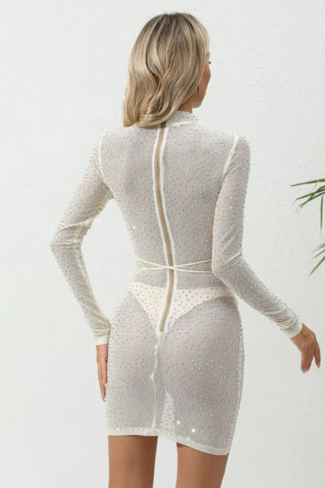 back view of a woman in a white sparkly sheer dress with a zipper closure