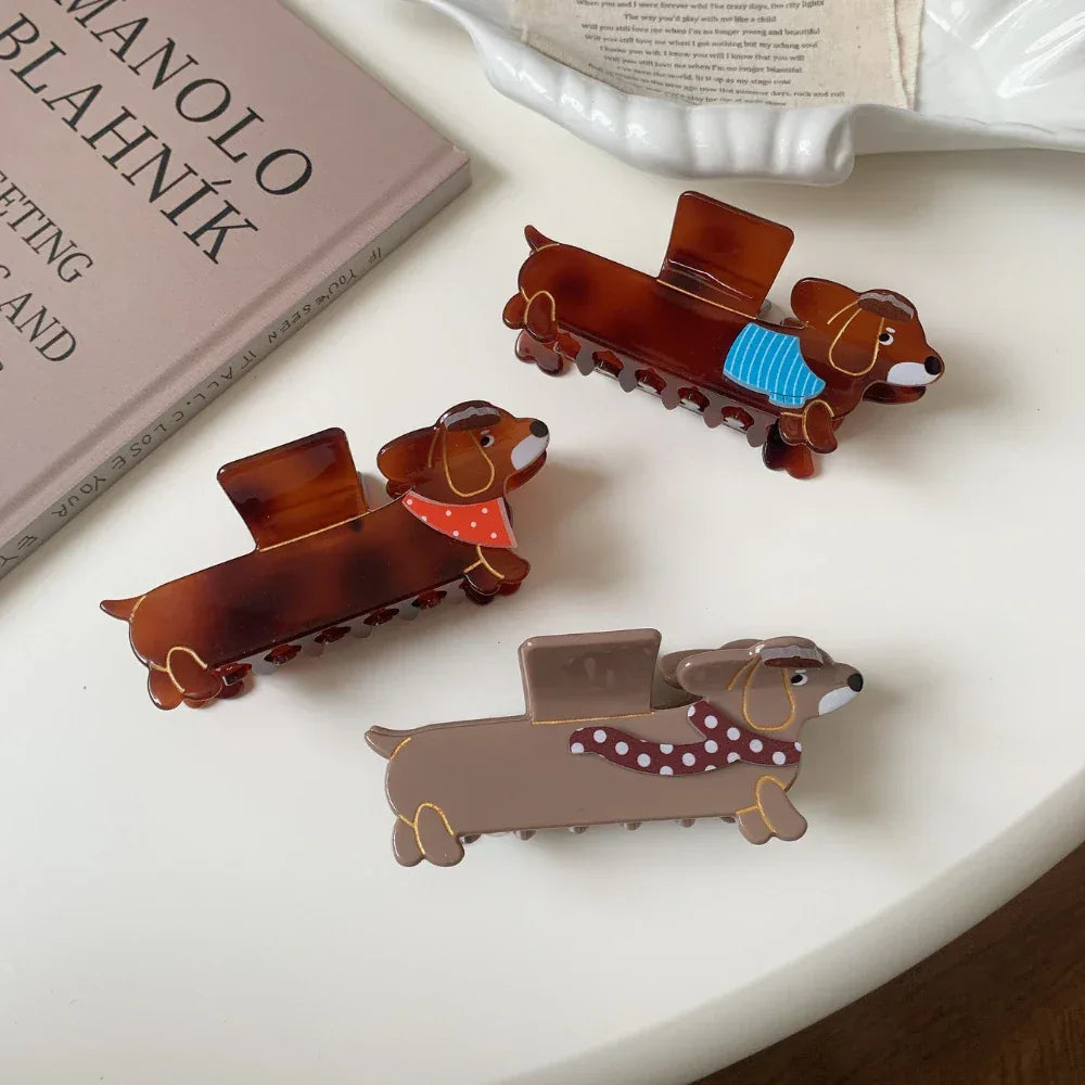Assortment of dachshund hair claw clips arranged on a white surface with a book