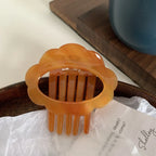 A close-up of an orange translucent cloud hair clip
