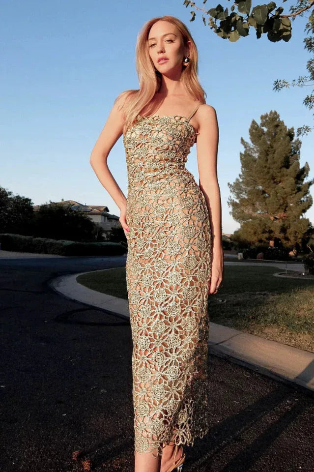 Woman with blonde hair wearing a gold lace maxi dress outdoors