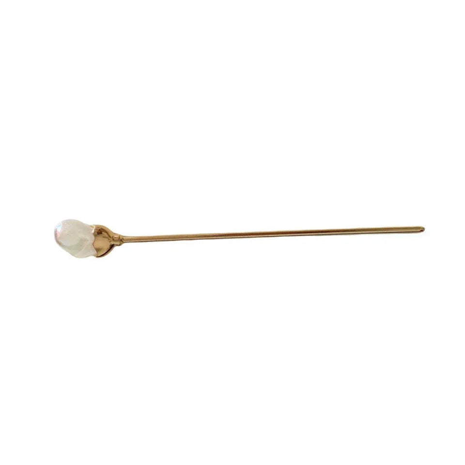 A gold-tone hairpin with a pearl-like embellishment is shown against a white background. Main image