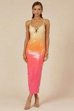 Front view of a model wearing a yellow, orange, and pink ombre sequined midi dress with spaghetti straps and a star embellishment at the bust, against a neutral background.