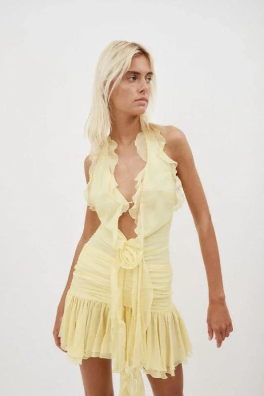 Close-up of a woman wearing a yellow ruffled halter mini dress