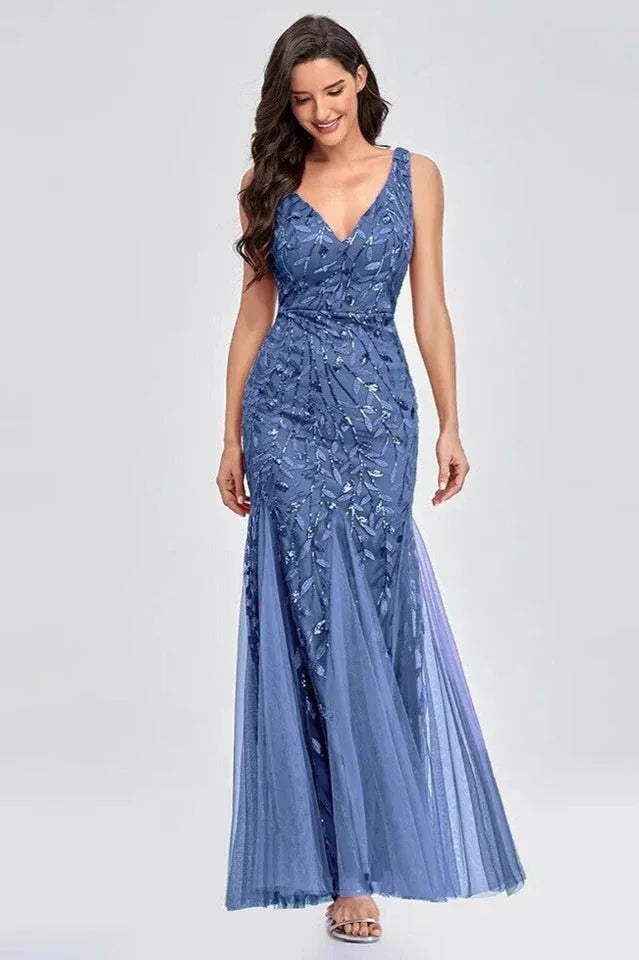 Woman wearing a floor-length blue sequined mermaid gown with a V-neckline and sleeveless design. Main image
