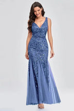 Woman wearing a floor-length blue sequined mermaid gown with a V-neckline and sleeveless design.