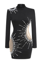Close-up of the front of a black long-sleeve mini dress with bead embellishments and cutouts.