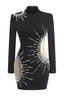 Close-up of the front of a black long-sleeve mini dress with bead embellishments and cutouts.