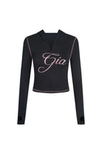 Front view of the black long-sleeve zip-up top with pink embroidery and contrast stitching.