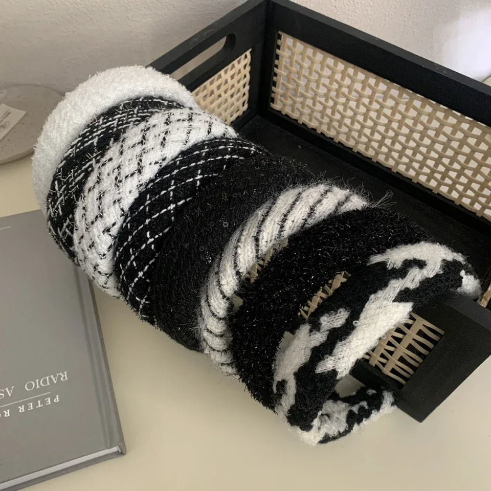 Stack of black and white tweed headbands in a basket Secondary image