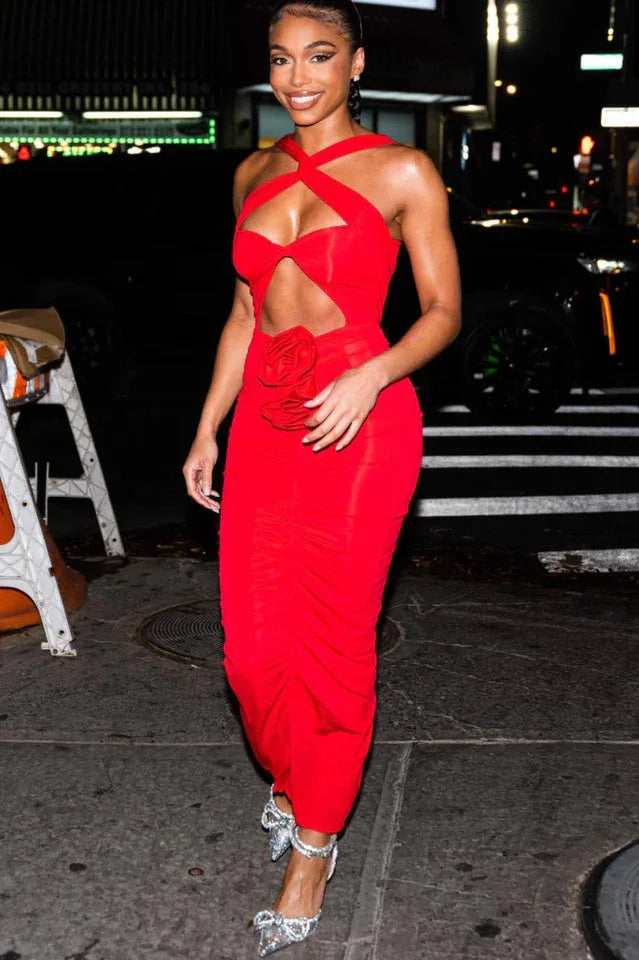 woman smiling in a red halter neck maxi dress with cutout and rose detail at night
