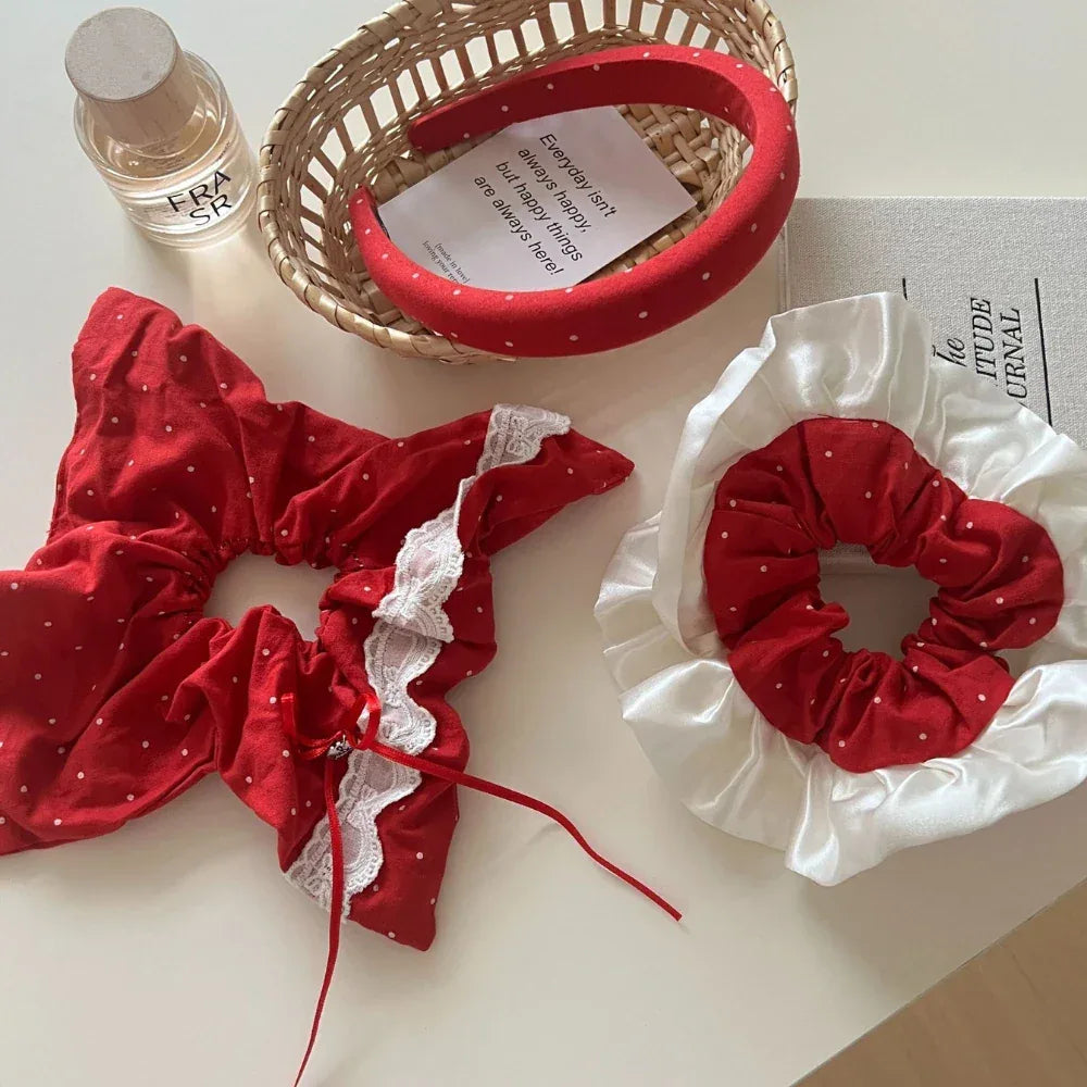 Collection of red polka dot hair accessories including a headband and scrunchies with lace trim