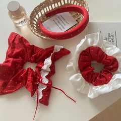 Collection of red polka dot hair accessories including a headband and scrunchies with lace trim