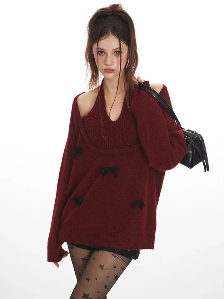 Close-up of a woman wearing a burgundy layered sweater with black bows, black star-patterned tights, and black boots, holding a black handbag.