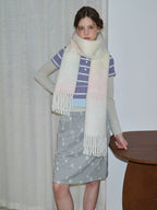 Woman wearing a pastel ombre scarf with a striped shirt and star-patterned skirt.