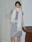 Woman wearing a pastel ombre scarf with a striped shirt and star-patterned skirt.