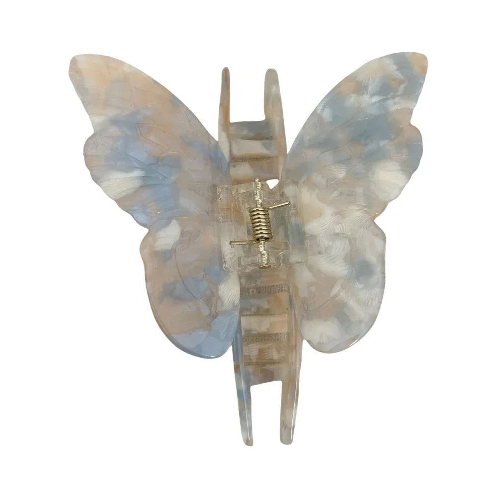 A butterfly-shaped hair claw clip with a marbled blue, white, and beige pattern. Main image