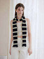 Front view of a woman wearing a black and white striped scarf around her neck
