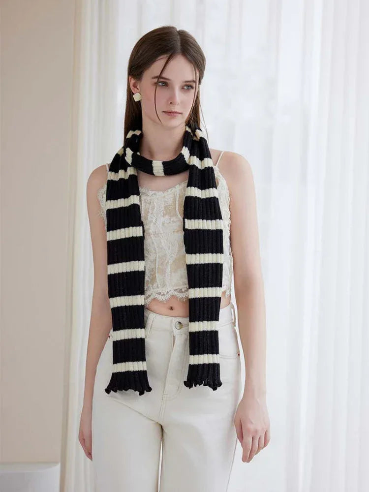 Front view of a woman wearing a black and white striped scarf around her neck