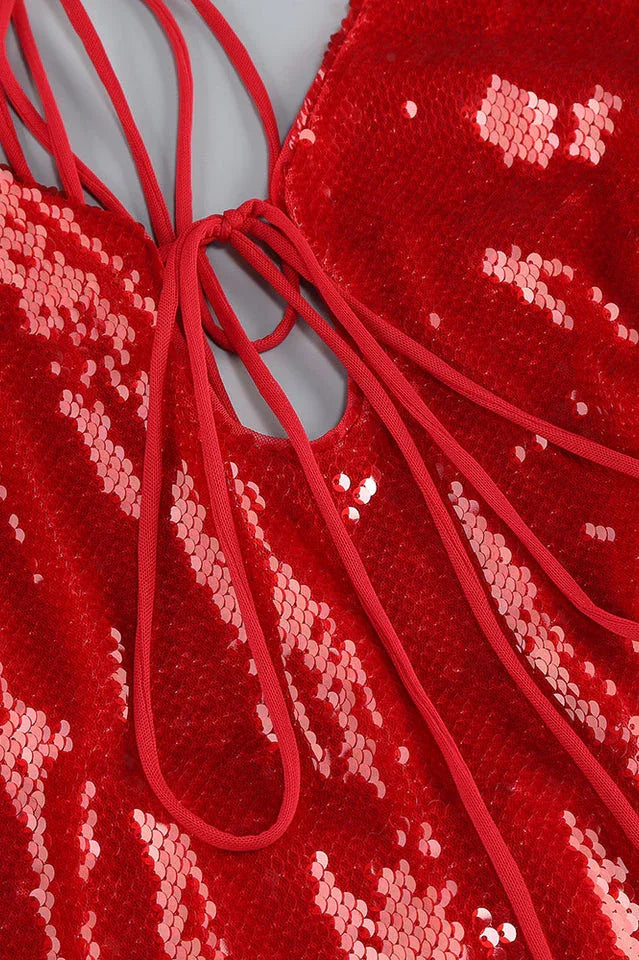 Close-up of the tie-front detail and sequin embellishment on a red dress.