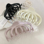 set of three octopus claw hair clips in black, cream, and pink