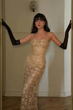 Woman in a gold floral lace dress and long black gloves