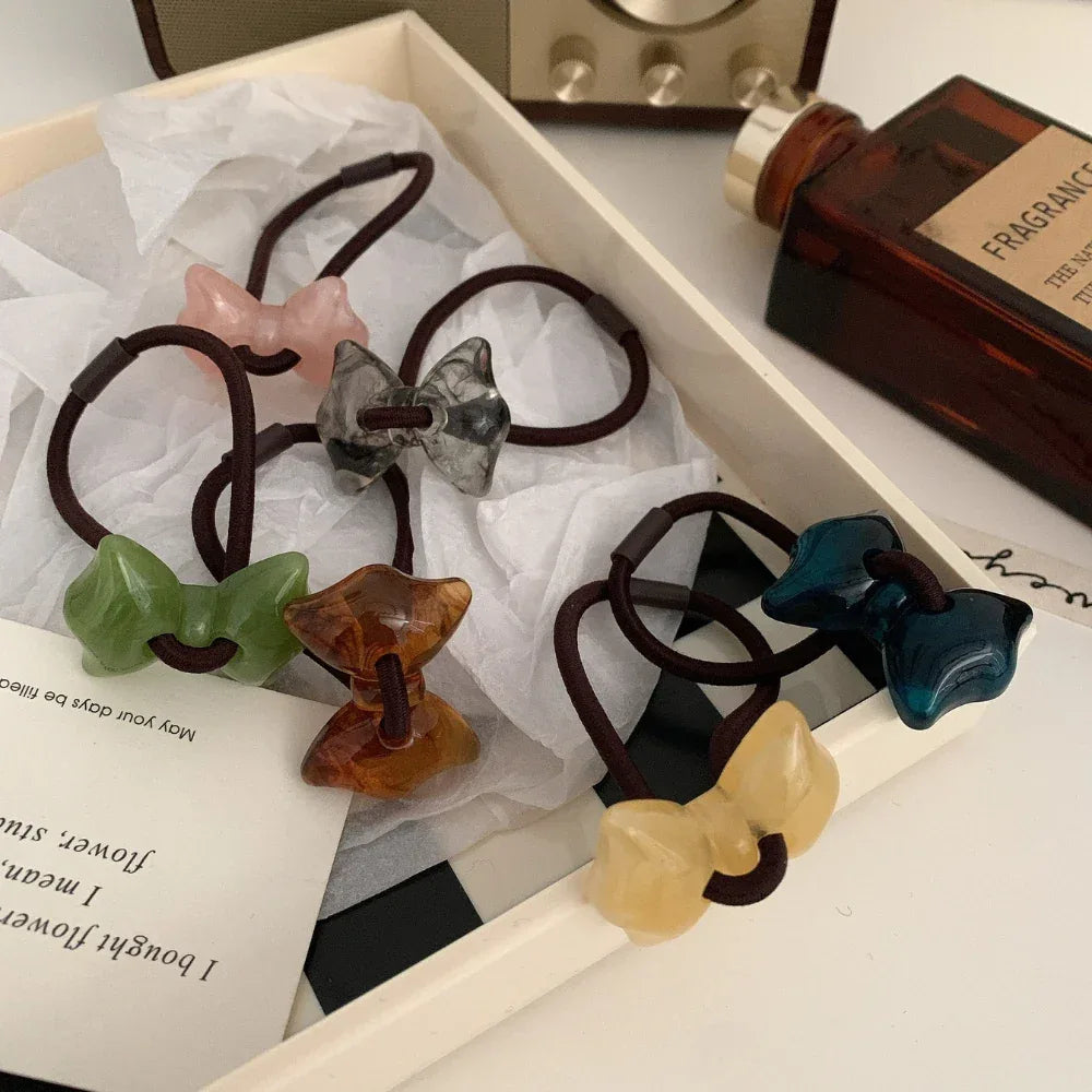 Set of colorful bow-shaped hair ties in a box