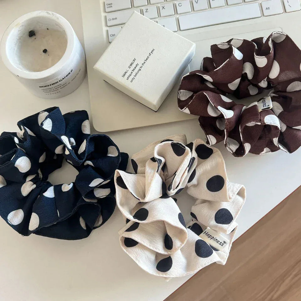 three polka dot scrunchies on a desk with a candle and jewelry box Secondary image
