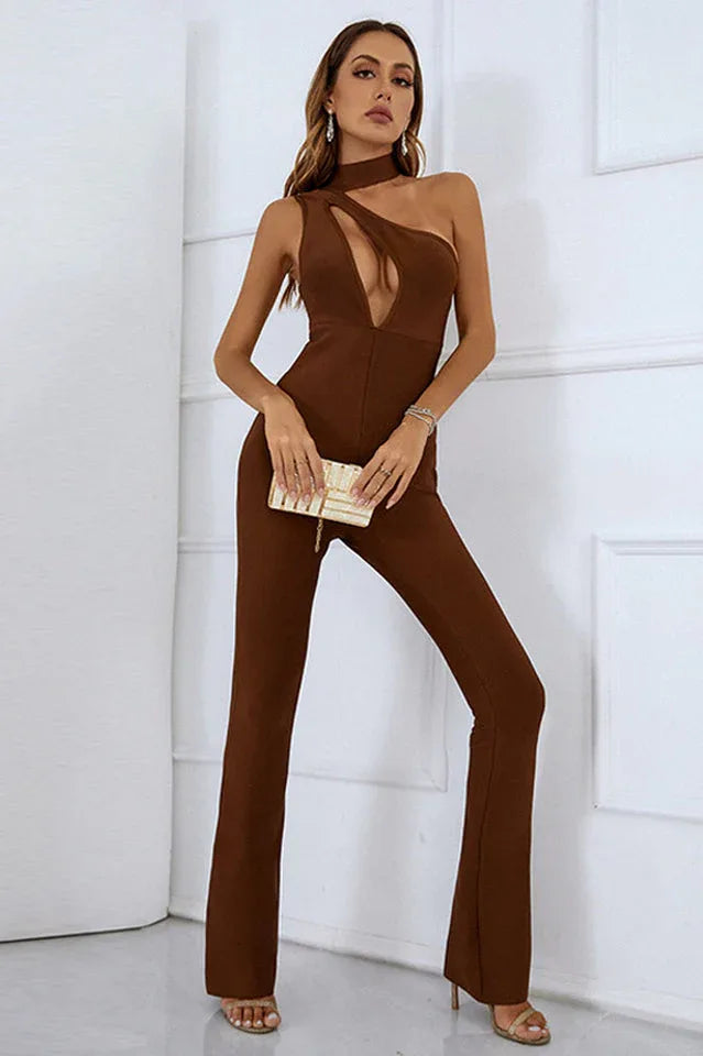 Woman wearing a brown one-shoulder jumpsuit with a cut-out detail and flared legs, holding a clutch. Main image