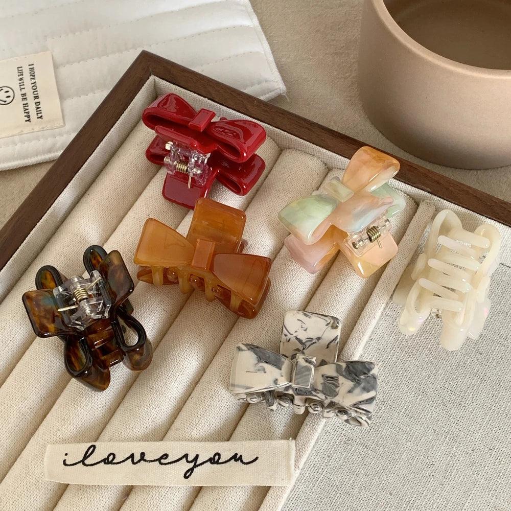 close-up of various bow claw clips displayed in a wooden tray