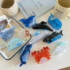 Multiple hair claw clips featuring whale, dolphin, and crab designs