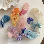 Overhead view of multiple acrylic jellyfish hair clips arranged on a white surface, showcasing different colors and designs.