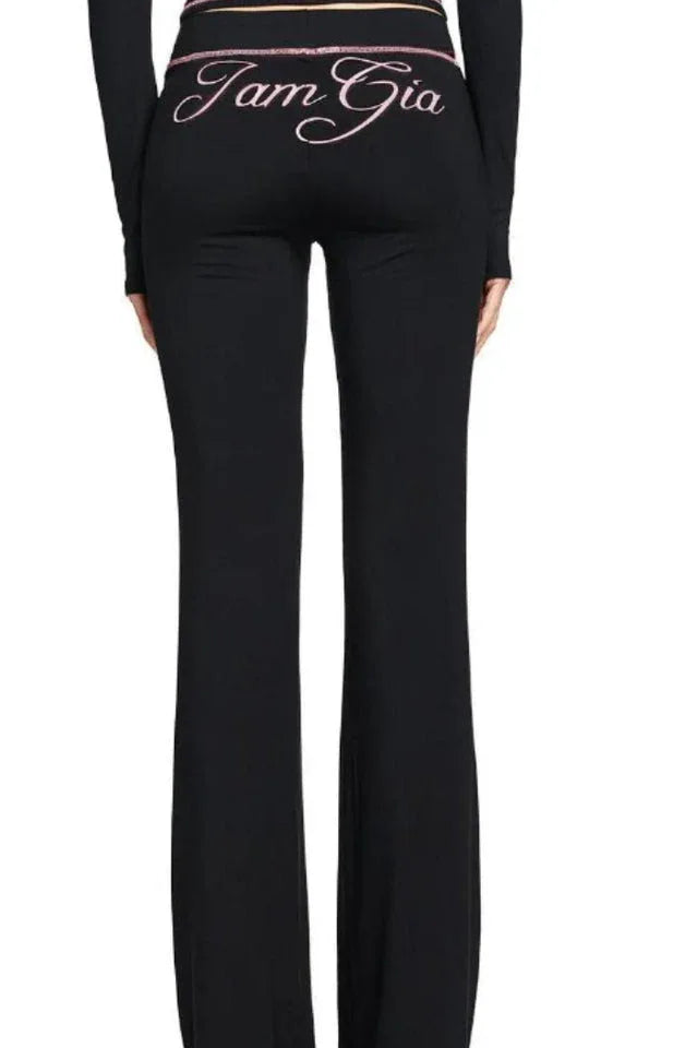 Back view of the black flared pants with embroidered text 'I Am Gia'.