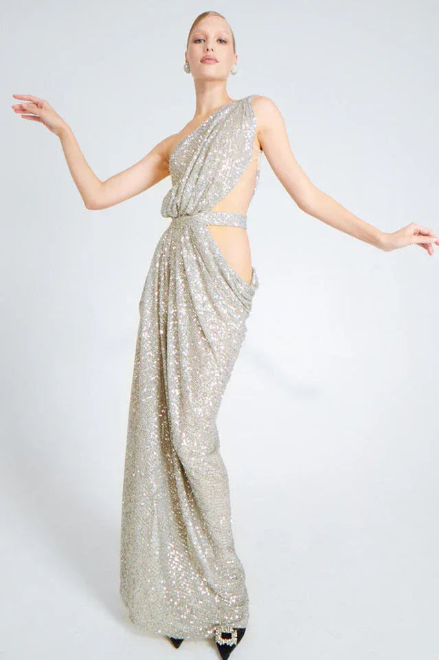 Model posing in a silver sequined one-shoulder draped gown