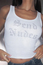 Close-up of a woman wearing a white ribbed knit tank top with rhinestone "Send Nudes" graphic and blue jeans