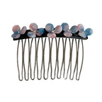 Close-up of a hair comb with pink and blue floral embellishments and clear gemstones