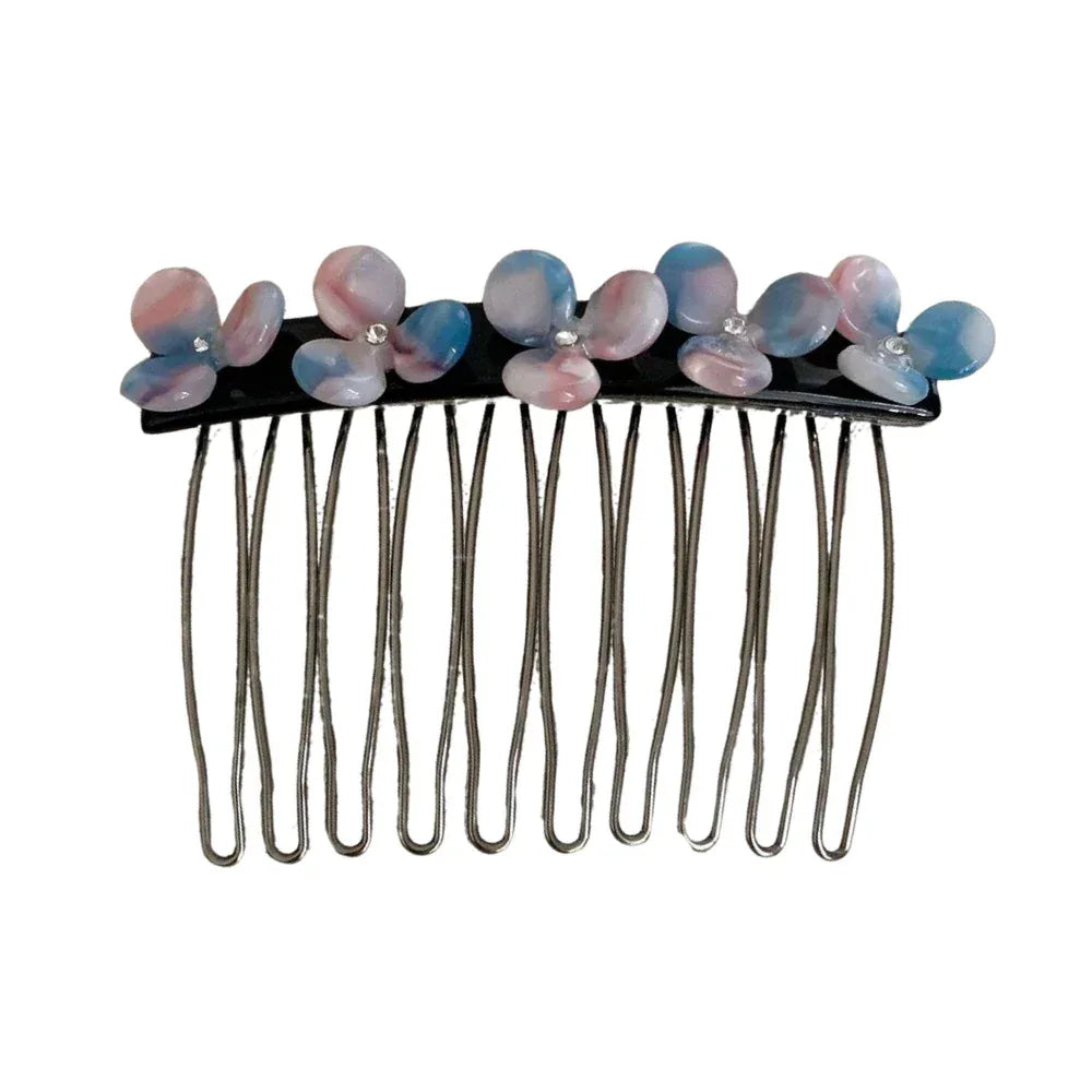 Close-up of a hair comb with pink and blue floral embellishments and clear gemstones