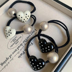 Close-up of heart-shaped hair ties with polka dots and silver beads in a tray