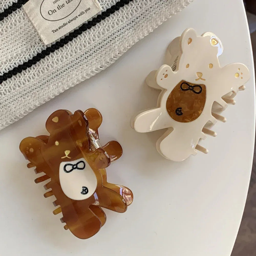 overhead view of a brown and a cream bear claw hair clip on a white surface