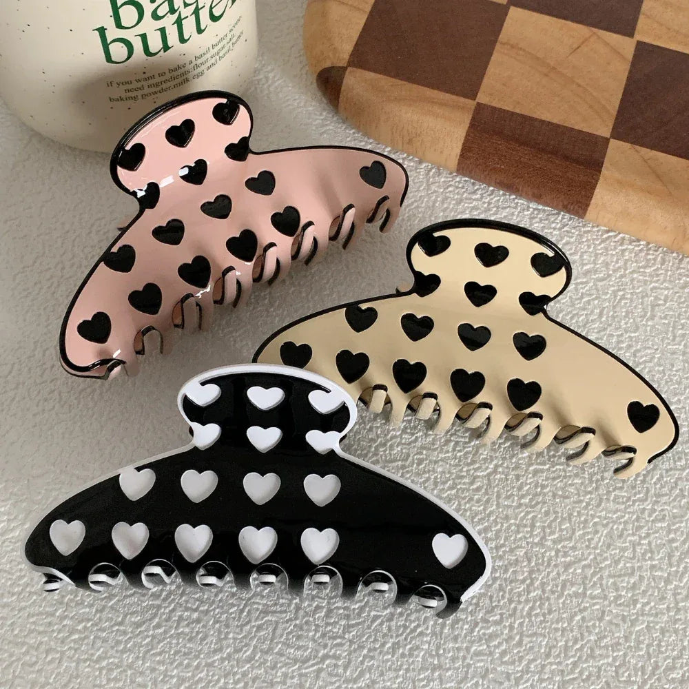 three heart pattern claw clips in pink, beige, and black