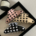 three heart pattern claw clips arranged in a frame