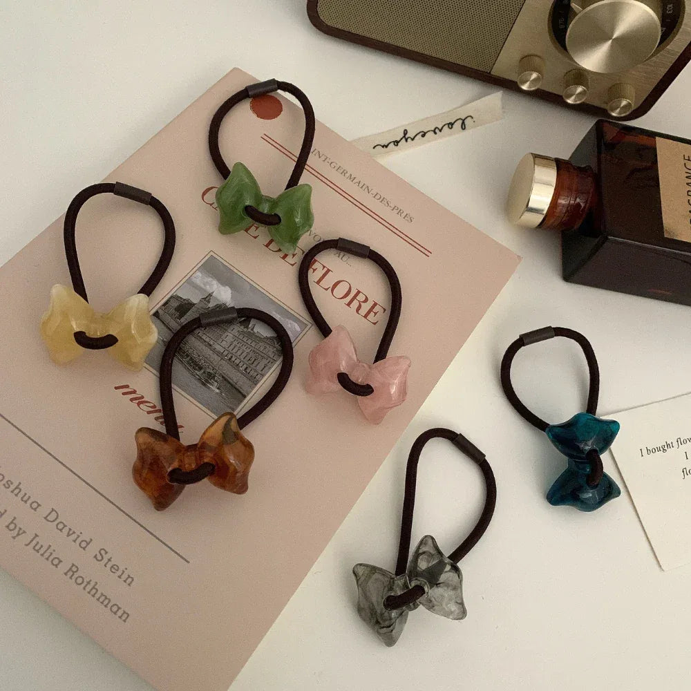 Assortment of bow-shaped hair ties on a book