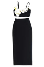 Black crop top with floral embellishments and a matching midi skirt, displayed separately.