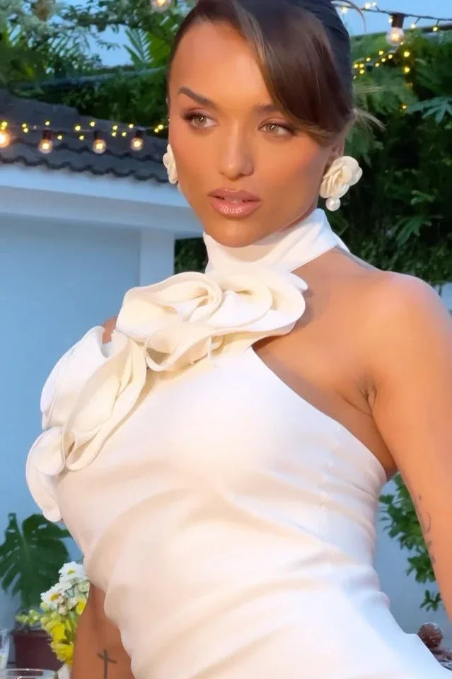 Close-up of a woman in a white satin gown with floral applique, showcasing the neckline detail.